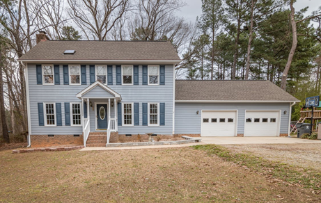 Brown and gray home with white garage doors