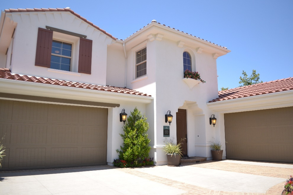 Front view of a house with a brown garage door 
