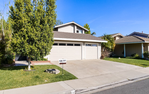 A house in front of the road with white garage doors
