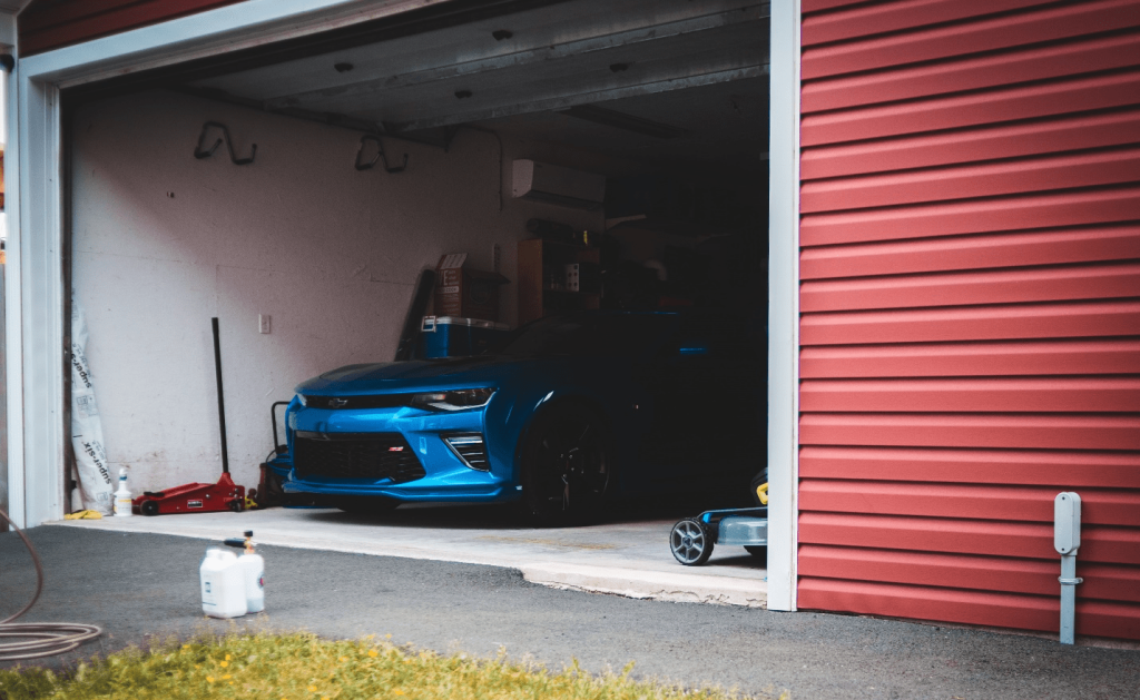  Car parked inside a garage with the door opened.