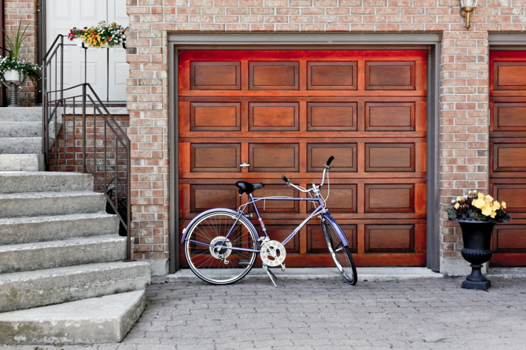 A cycle parked in front of a garage door